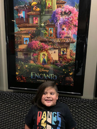  The author's son with a poster for the movie "Encanto." 