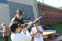  Amateur radio operator and ARISS volunteer Will Marchant helps students perfect their antenna pointing techniques. Amateur radio operator Anne Marchant is in the background working with the rest of the class while the contact is going on. Photo courtesy of Winchester Starbase Academy 