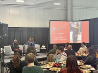  Betty Bayé and Sadiqa Reynolds speak to the crowd at a luncheon that raised $2,000 for the Sadiqa Reynolds Scholarship for Mental Health Resilience. Photo Credit: Bonnie Jean Feldkamp 