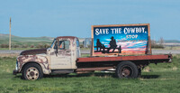 A truck displays a "Save the Cowboy" protest sign on Montana roadside. Photo credit: Erica Feldkamp.
