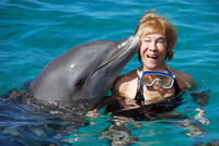 The author enjoys a kiss from the dolphin with which she has been swimming at the Royal Sea Aquarium on the Caribbean island of Curacao. Photo courtesy of Victor Block.