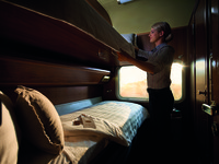  An attendant on the Indian Pacific excursion train in Australia converts the seat in a Gold Class compartment to bunk beds. Photo courtesy of Great Southern Rail 