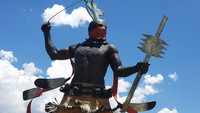 . Craig Dan Goseyun's towering sculpture, "Apache Mountain Spirit Dancer," stands before the Museum of Indian Arts and Culture in Santa Fe, New Mexico. Photo courtesy of Jim Farber.