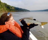The author examines the fish she has just caught at Iguazu National Park in Argentina. Photo courtesy of John Coburn.