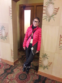 A visitor to the Surf Ballroom in Clear Lake, Iowa, poses in Buddy Holly glasses in front of the phone booth where the singer made his last phone call to his wife before he died. Photo courtesy of Steve Bergsman.
