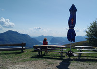 A hiker stops at Alpe Rompiago to take in views above Switzerland's Lake Lugano. Photo courtesy of Athena Lucero.