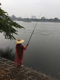  A woman fishes on the banks of Truch Bach Lake, where John McCain's plane was shot down in Hanoi, Vietnam. Photo courtesy of Kitty Morse. 
