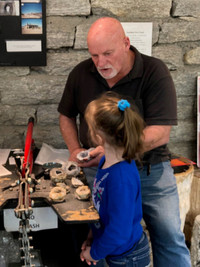  A member of the Gem and Mineral Society in Hendersonville, North Carolina, opens a geode for a child celebrating her birthday. Photo courtesy of Bill Neely. 