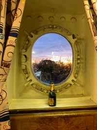 A decorated porthole on the Queen Mary that looks out over California's Long Beach Harbor also provides a good spot for the guests' champagne. Photo courtesy of Kitty Morse.