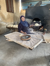  A woman makes bread for visitors to Sakkara, Egypt, near Cairo. Photo courtesy of Phil Allen. 