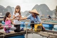 . Children learn to fish with a local in Vietnam. Photo courtesy of G Adventures. 