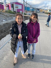  Native girls greet passengers from a cruise ship in Nanortalik, Greenland. Photo courtesy of Sharon Whitley Larsen. 