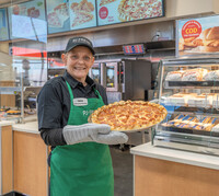  A server at a Pilot Flying J truck stop brings fresh pizza out to hungry road warriors. Photo courtesy of Ed Rode. 