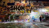Heather Hahn, co-owner of Lantern Records, shows off a secret alleyway full of art in Olympia, Washington. Photo courtesy of Jim Farber.