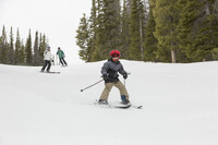  A young skier tries out a Wyoming mountain while his parents look on. Photo courtesy of Visit Laramie. 
