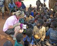 . An American volunteer helps teach African children. Photo courtesy of Lifeontheside/Dreamstime.com. 