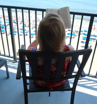  Reading on the balcony at a hotel in Rehoboth, Delaware, is one of the author's favorite pastimes on a do-nothing vacation. Photo courtesy Victor Block. 