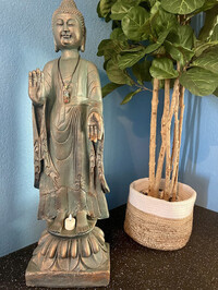  A Buddha statue stands serenely next to an artificial fiddle-leaf tree and sheer spa curtains tied with a shell necklace strand brought home from the author's family travels to Indonesia. Photo courtesy of Nicola Bridges. 