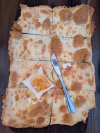  At Davanti Enoteca restaurant in San Diego's Little Italy, addicting Focaccia Di Recco &#8212; Ligurian flatbread with soft cow's milk cheese and honeycomb &#8212; is a favorite made for sharing. Photo courtesy of Athena Lucero. 