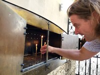 A visitor lights a candle in a lumanarar — a traditional Romanian shrine for prayers to the living and the dead — outside Stavropoleos Monastery in Bucharest's Old Town. Photo courtesy of Carmen Zermeno.