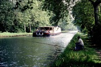  A French Waterways barge encounters a fisherman along a canal in Loire. Photo courtesy of Victor Block. 