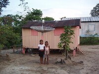  Children wave from in front of their home to passengers in a vessel on the Amazon River. Photo courtesy of Victor Block. 