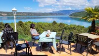  A traveler enjoys a glass of wine while overlooking Lac St. Croix in Haute Provence, France. Photo courtesy of Tom Olson. 
