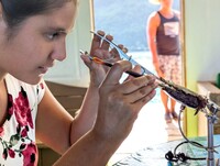 Rama, a pearl farmer in Tahiti, extracts a pearl from its shell. Photo courtesy of Athena Lucero.