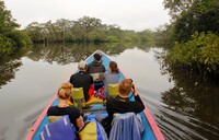  A group of travelers motor on the Cuyabeno River toward the remote Siona Lodge in Ecuador's Amazon region. Photo courtesy of Doug Hansen. 