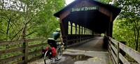 A cyclist rides over the 'Bridge of Dreams,' the longest wood-covered bridge in Ohio. Photo courtesy of Jim Farber.